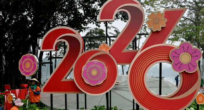 Workers tend to flowers next to a 2026 New Year banner in Hanoi on December 31 2025. Photo by Nha